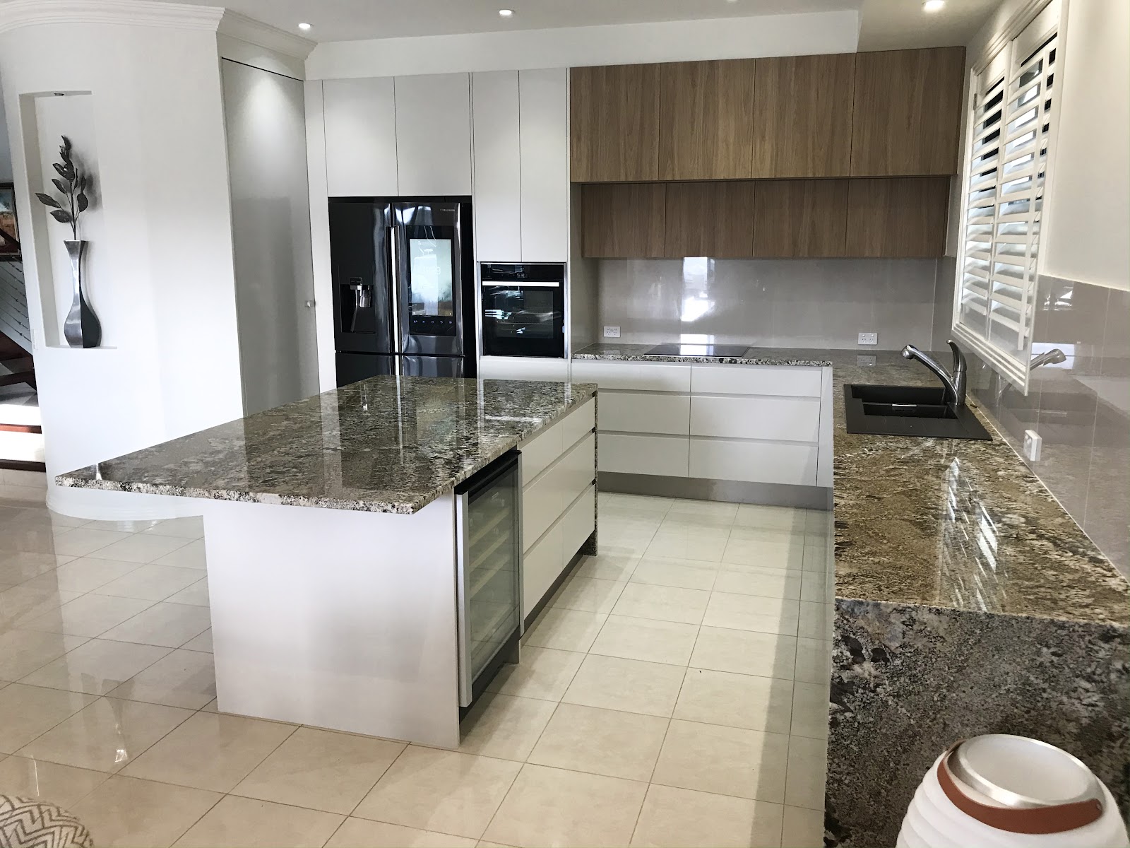 Granite and walnut kitchen with plantation shutters