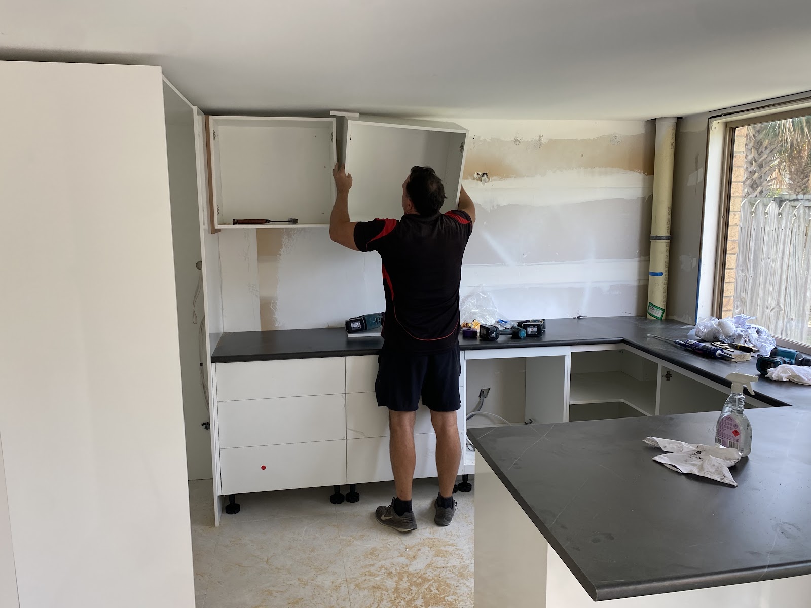 Wall cabinets being hung during a kitchen install